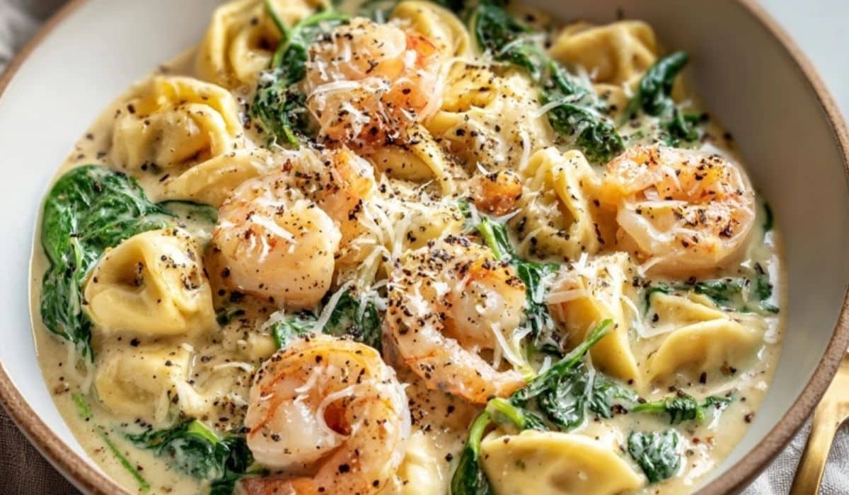 Creamy Shrimp and Spinach Tortellini in a bowl with cheese and black pepper