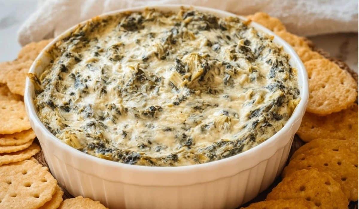 Crockpot Spinach Artichoke Dip served with crackers in a white dish
