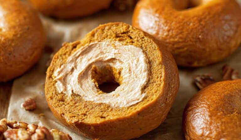 Homemade Pumpkin Bagels sliced and spread with cinnamon cream cheese
