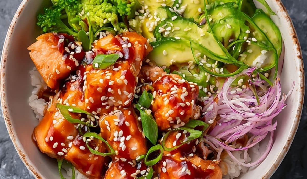 Featured Honey Sriracha Salmon Bowl topped with sesame seeds, avocado, and vibrant vegetables