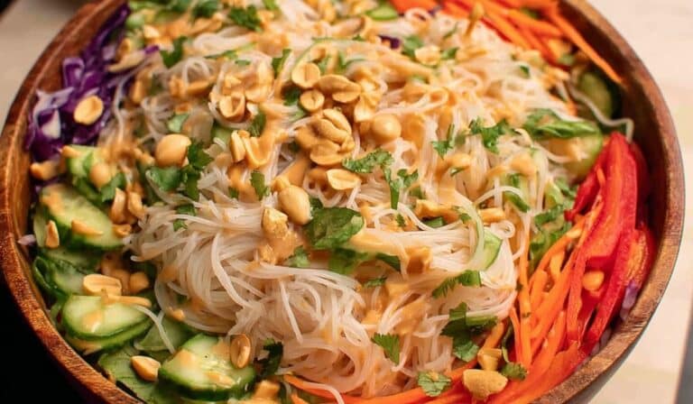 Spring Roll Salad with Peanut Sauce in a wooden bowl topped with crushed peanuts