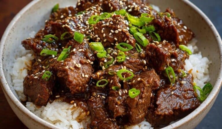 Crockpot Korean BBQ Beef served over rice with sesame seeds and green onions