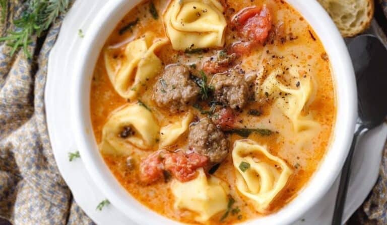Easy Crockpot Sausage and Tortellini Soup served hot in a white bowl