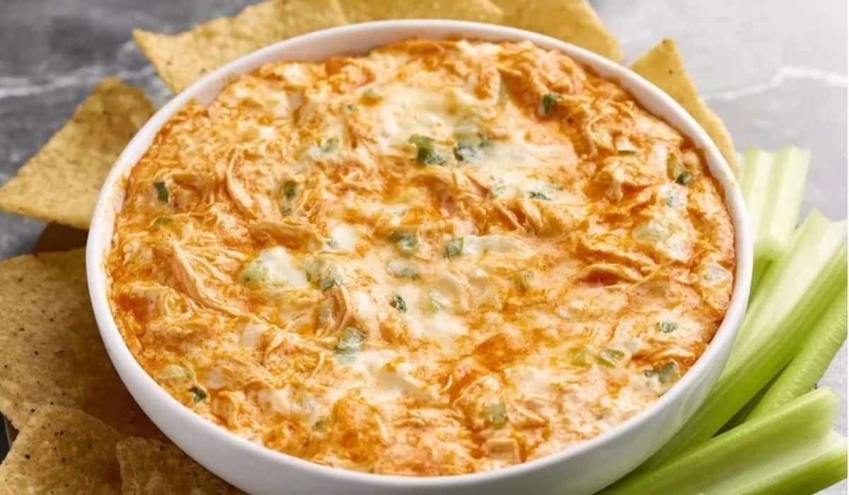 Greek Yogurt Buffalo Chicken Dip baked golden with celery and chips