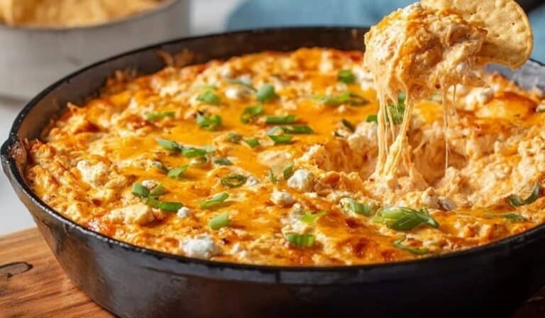 Buffalo Chicken Dip in cast iron skillet with chip
