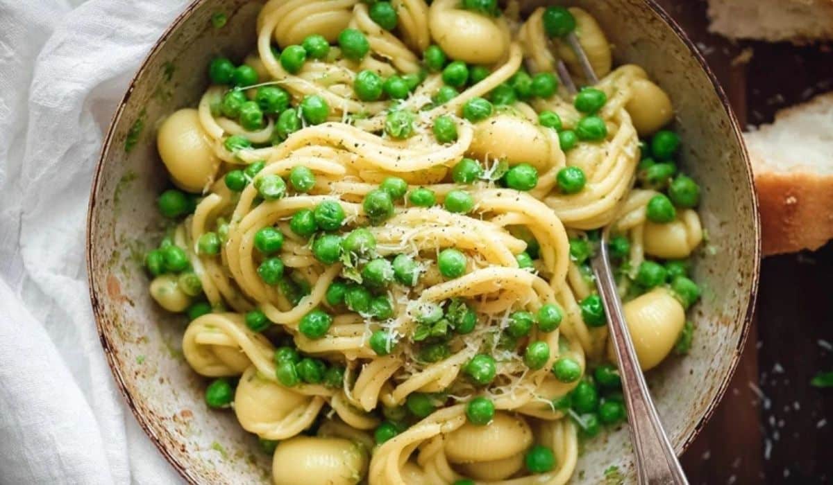 One-pot Pasta with peas served in a bowl topped with parmesan and peas