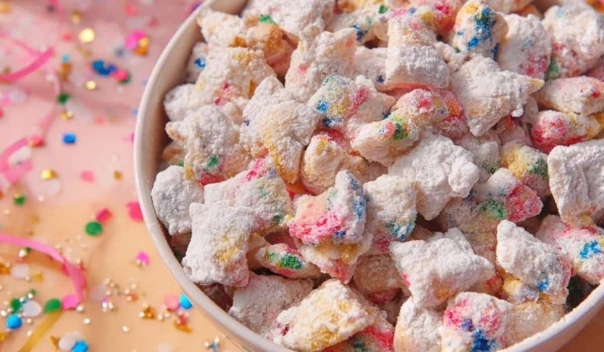 Cake Batter Puppy Chow in a bowl with rainbow sprinkles