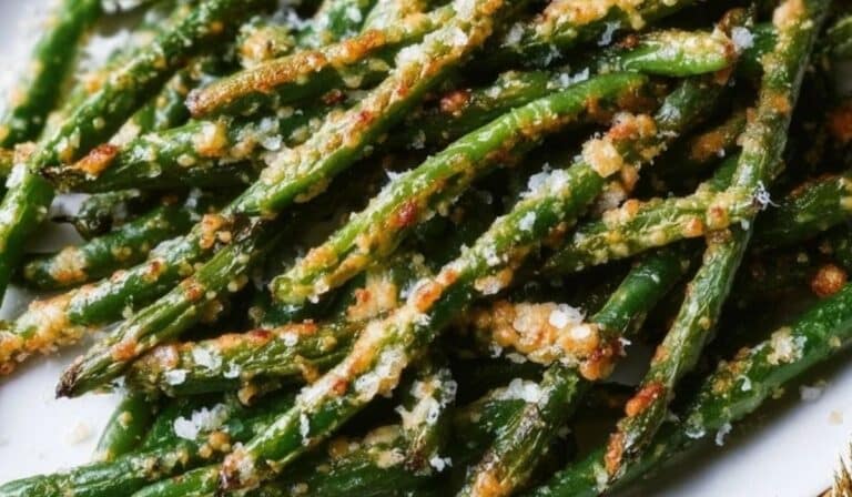A golden batch of Crispy Oven Baked Green Beans with Parmesan featuring perfectly roasted cheese edges and vibrant green beans.
