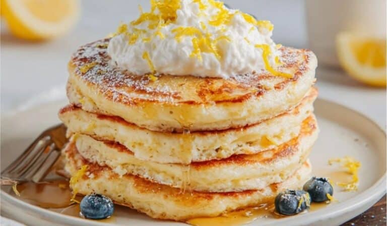Lemon ricotta pancake stack with blueberries, syrup, and lemon zest