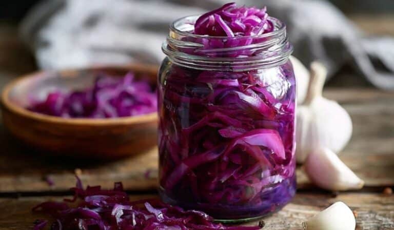 Red cabbage fermented pickle in a glass jar with glossy tangy shreds